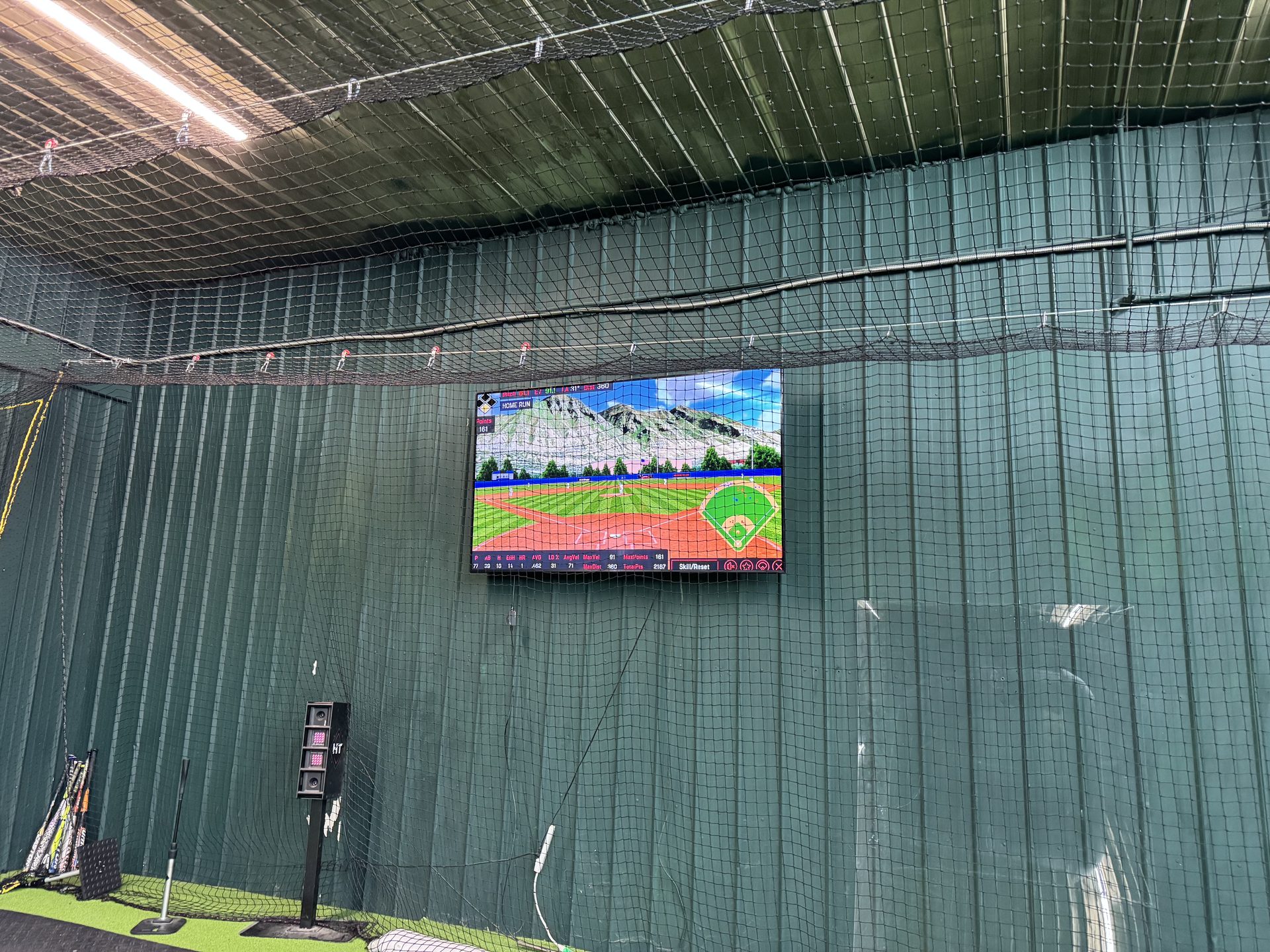 Wide-angle view of Chenango SportsZone batting cages with green turf and netting
