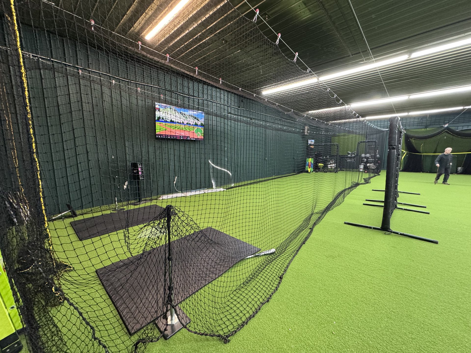 Completed Chenango SportsZone facility with batting cages, green turf, and HitTrax